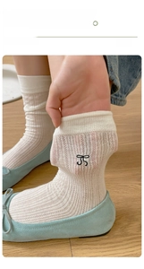 Close-up of white sheer bow socks with vertical stripes showing elasticity and breathability