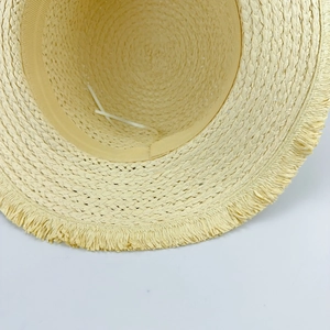 Detailed close-up of straw sun hat featuring frayed edges and adjustable inner sweatband