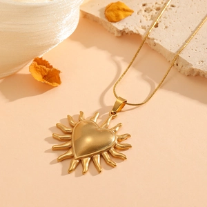 18K gold plated stainless steel sunburst heart pendant necklace on textured stone base
