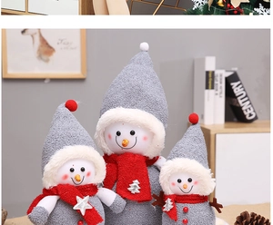 Detailed close-up of three grey knitted snowman dolls with festive red sequin scarves