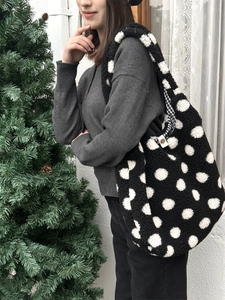 Détail du sac seau pelucheux à pois noirs et blancs avec texture en fausse fourrure