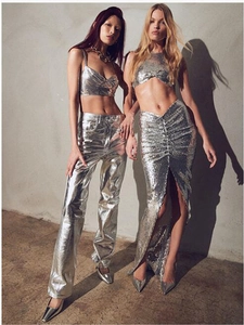 Détail d'un ensemble crop top et jupe longue à paillettes argentées avec fente haute