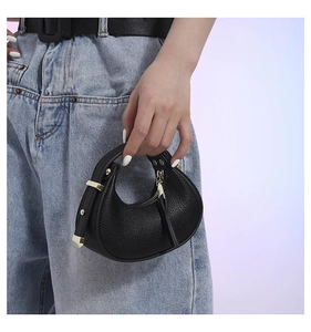 Detail of premium black pebble leather hobo bag with elegant gold metal hardware buckle