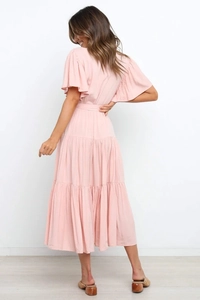 Vista detallada del vestido boho rosa con falda de capas y elegantes volantes