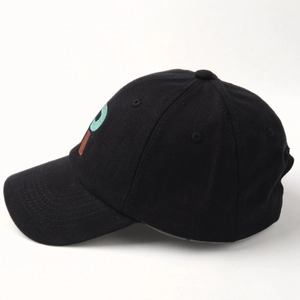 Close-up of the contrasting embroidered letter P on a black cotton baseball cap side view