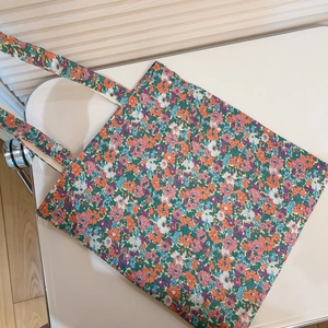 Detail view of large floral print cotton tote bag with vibrant orange and purple flowers