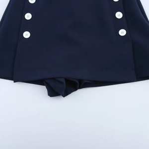 Detail view of navy blue skort with double-breasted white buttons and smooth hem