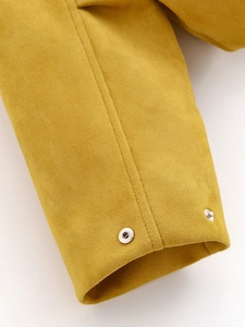 Detailed shot of yellow faux suede jacket cuff featuring silver metal snap buttons