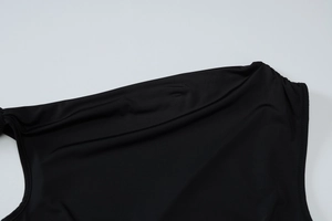 Détail d'une robe noire à une épaule montrant la texture du tissu élastique lisse