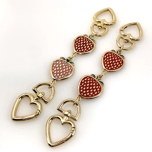 Detail of strawberry charm bag extension chains in red and pink enamel with gold clasps