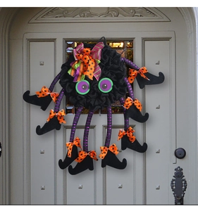 Close-up of Halloween spider wreath featuring purple striped legs and black witch boots