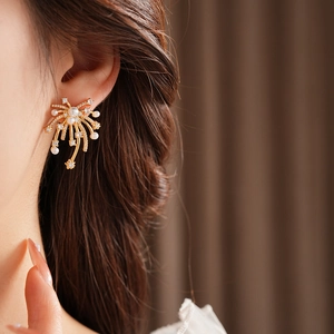 Macro shot of 18K gold plated fireworks earring with white pearls and diamonds