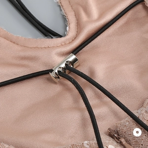 Detalle de vestido satinado champán con encaje, lentejuelas y cierre de cordón metálico