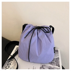 Detail shot of the lavender purple nylon drawstring bucket bag with black strap