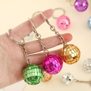 Close-up of vibrant disco ball keychains in green, pink, and gold mirrored finishes