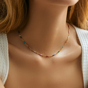 Detail of colorful beads and enamel drops on a gold-plated bohemian necklace for women