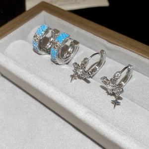 Detail of silver hoops with zircon cross pendant and turquoise beaded earrings