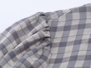 Macro d'un tissu à carreaux gris montrant la texture plissée et le tissage détaillé