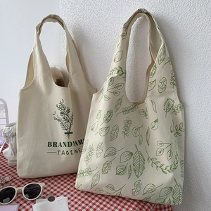 Minimalist canvas tote bags featuring botanical prints in a cozy indoor lifestyle setting