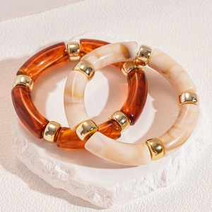 Detail of amber tortoiseshell and marble resin bracelets with gold ring spacers