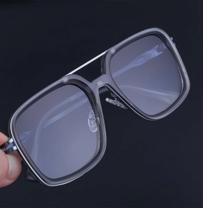 Detail view of square double-bridge metal aviator frame in dark grey with clear lenses