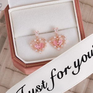 Detailed macro view of pink heart-shaped earrings in a luxury octagon gift box