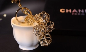 Close-up of golden geometric prism keychain featuring high-clarity clear crystals