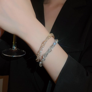 Detail of elegant gold and silver multi-layer twisted bracelets with sparkling rhinestones