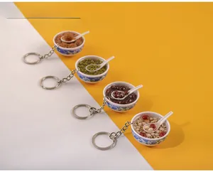 Detailed close-up of miniature PVC food keychains with traditional blue pattern bowls