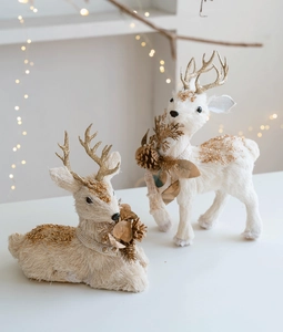 Close-up of white and gold reindeer figurines with glitter antlers for Christmas decor