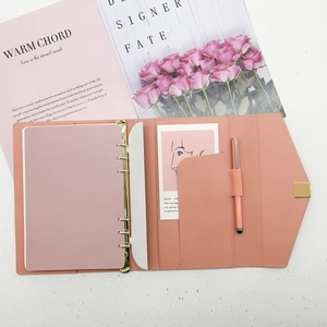 Pink leather binder with 6-ring metal binder clips, card slots and matching ballpoint pen