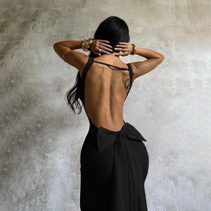 Close-up of the back of a black dress with a large bow detail and open-back design