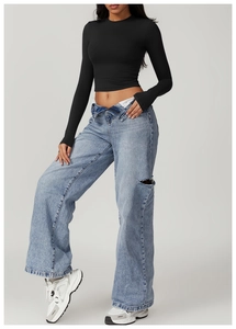 Close-up detail of slim-fit athletic long sleeve top and high-waist denim pants