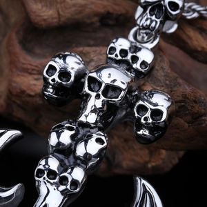 Macro detail of punk skull cross anchor pendant in polished silver stainless steel