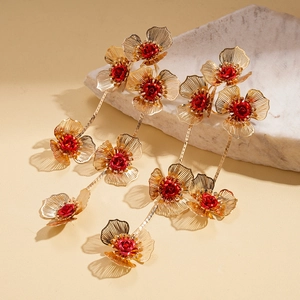 Détail de fleurs en maille dorée avec cœurs de roses rouges et longues chaînes