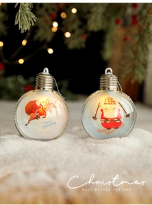Detail view of two transparent Christmas LED light balls with festive graphics on white snow