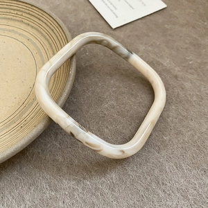 Macro-opname van vierkante hars armband met donkere schildpad marmeren textuur op keramiek