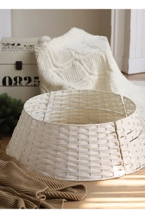 Close-up of white woven Christmas tree collar with natural textures on wooden floor