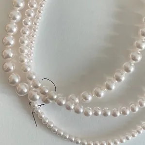 Macro detail of multi-layered 925 silver pearl necklace with various bead sizes