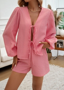 Dettaglio del set in seersucker a quadretti rosa e bianchi con scollo a V e lacci frontali
