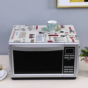 Linen dust cover with Travel Life cartoon print shown on a silver microwave oven