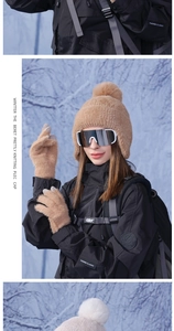 Close-up of light brown plush knit beanie and matching gloves against a snowy background