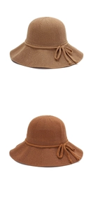 Detail of woven straw sun hats in two brown shades featuring fine knit texture and bow