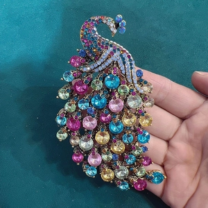 Detailed macro view of colorful crystal peacock brooch with vintage gold alloy base