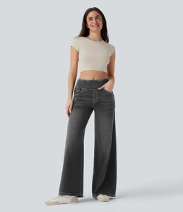 Detail einer dunkelgrau gewaschenen Jeans mit weitem Bein und einem beigefarbenen Crop Top