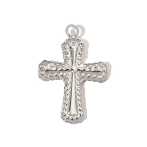 Macro shot of silver stainless steel cross pendant with textured grain border detail