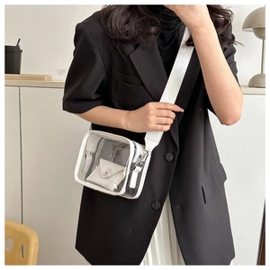 Close-up of white transparent PVC crossbody bag with wide strap on a female model