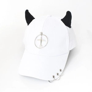 Detail of white baseball cap with black devil horns and silver metal rings on the brim