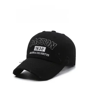 Close-up of vintage black baseball cap featuring white Boston 1630 embroidery and distressed details
