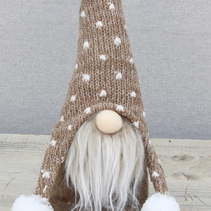 Gros plan d'un gnome de Noël nordique avec un chapeau tricoté et une barbe en fourrure